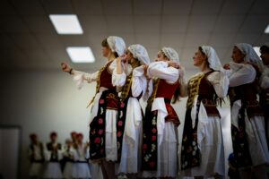 Women in traditional folk costumes performing a dance.