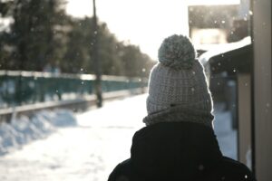 a person standing in the snow with a hat on