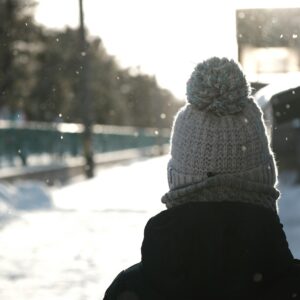 a person standing in the snow with a hat on